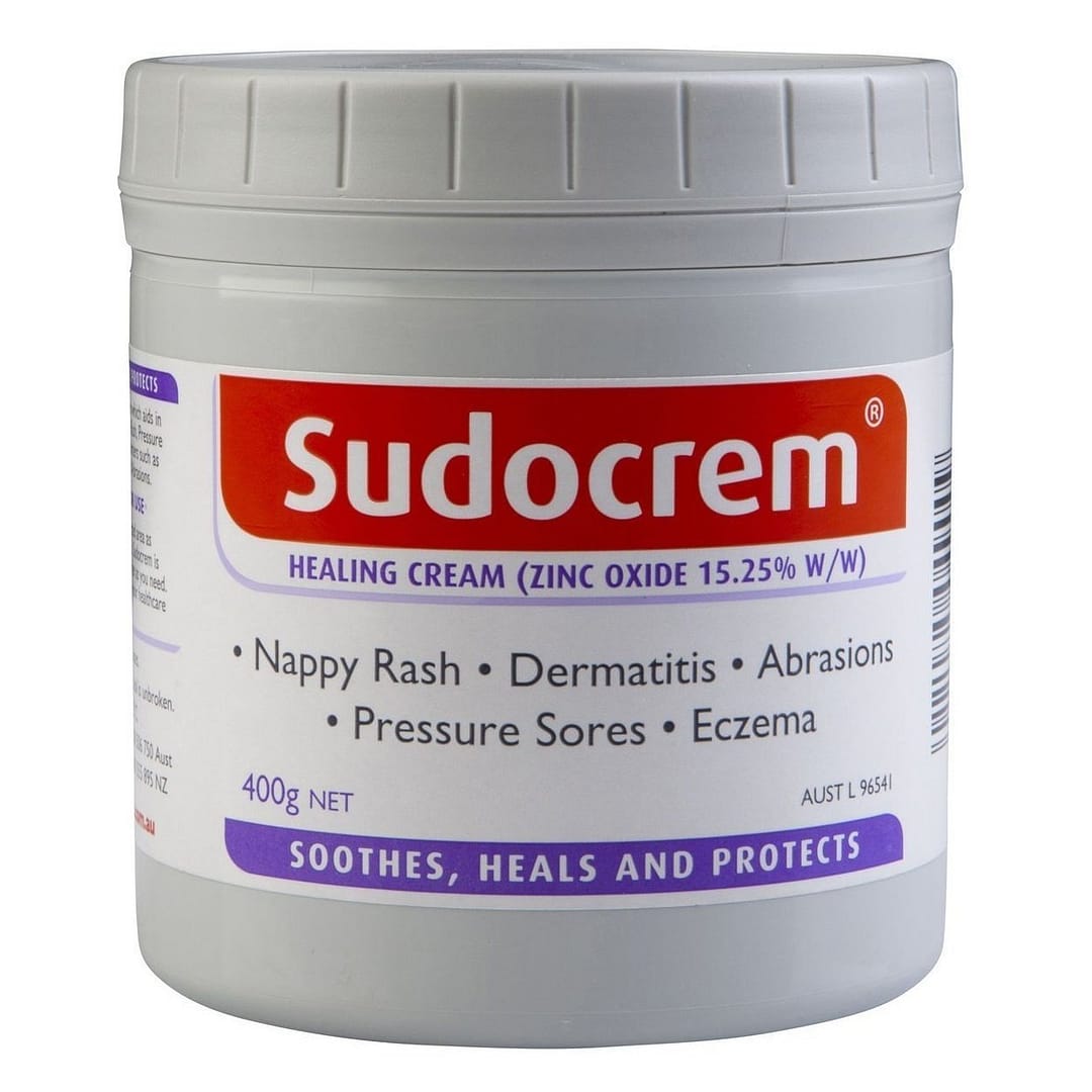 A 400g jar of Sudocrem, a healing cream primarily for conditions like nappy rash, dermatitis, abrasions, pressure sores, and eczema, featuring a white container with a red and purple label listing its uses and ingredients including 15.25% zinc oxide.
